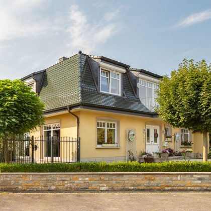 Seitliche Ansicht eines Stadthauses mit Biberschwanzziegel in tannengrün